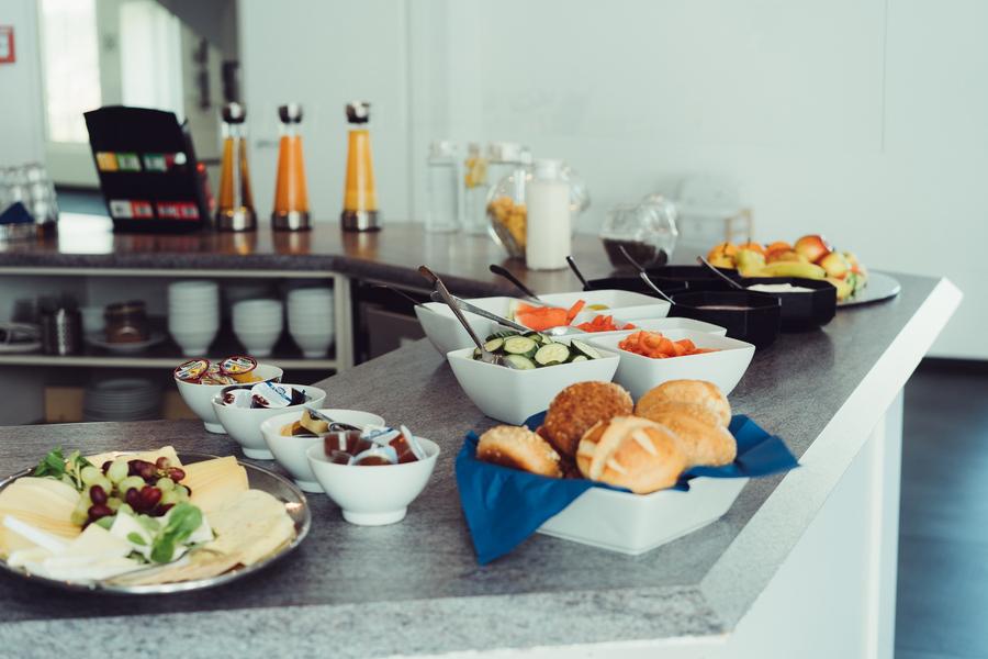Frühstücksbuffet mit Käseplatte, Brötchen und Obst