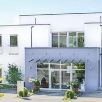 Weißes Gebäude mit blauem Eingangsbereich