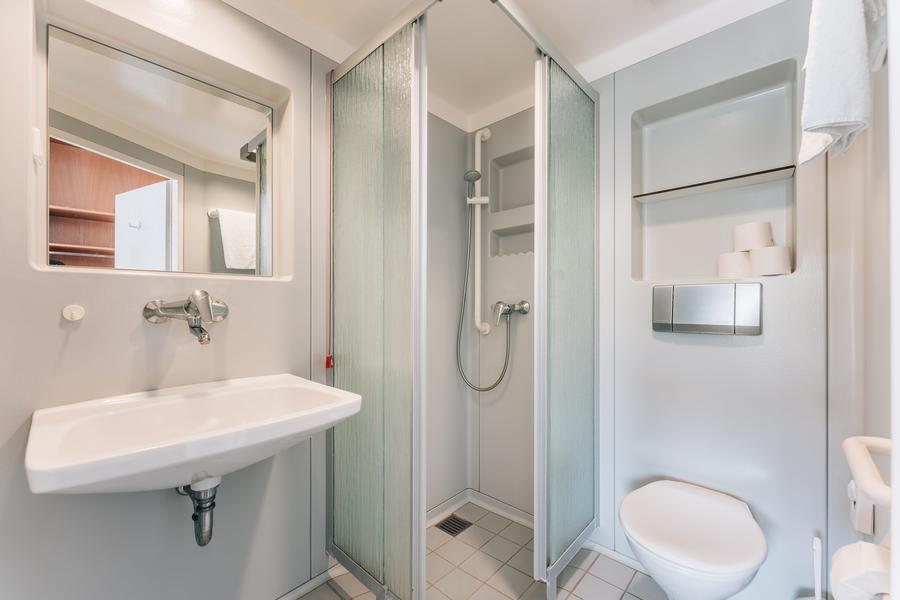 Helles Bad mit Dusche, WC und Waschbecken mit Spiegel