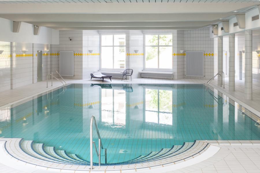 Großes Schwimmbecken mit blauem Wasser und Treppe