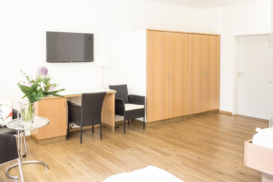 Zimmer mit Kleiderschrank und Schreibtisch aus Holz