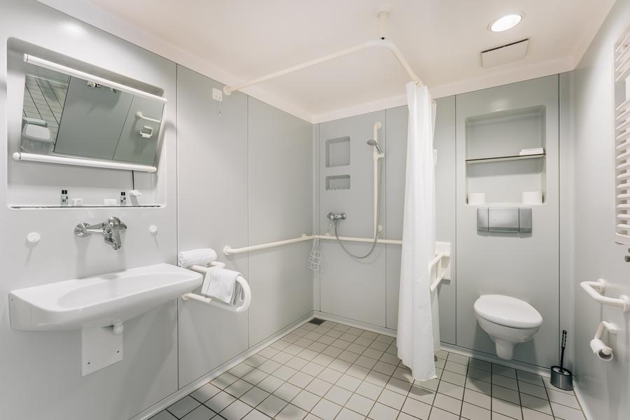 Helles, großes Bad mit barrierefreier Dusche, WC und Waschbecken mit Spiegel
