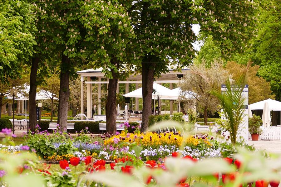 Außenbereich des Kursaals mit Park im Hintergrund und Bänken