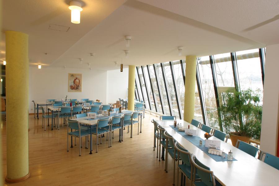 Speisesaal mit großen Fenstern und vielen Tischen