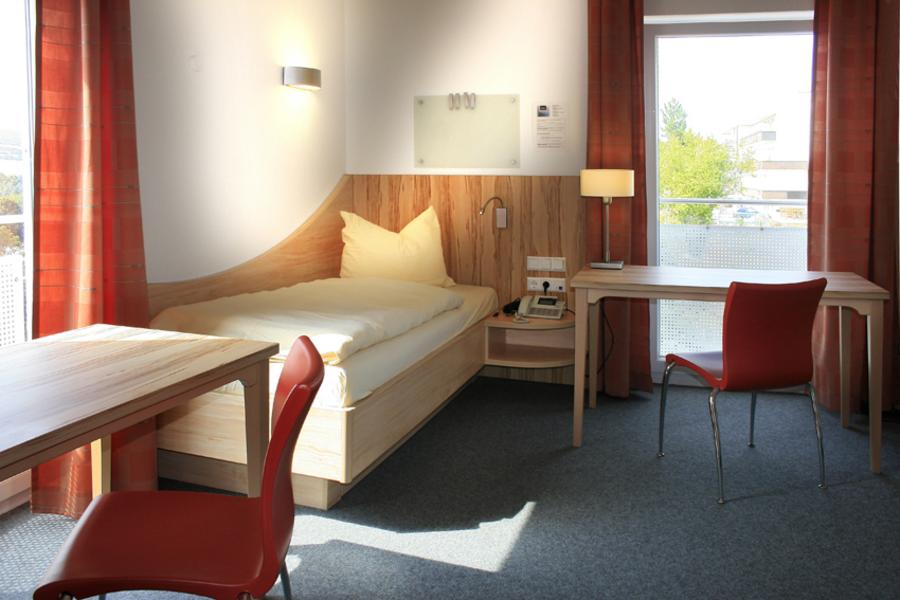 Zimmer mit Bett und Schreibtisch